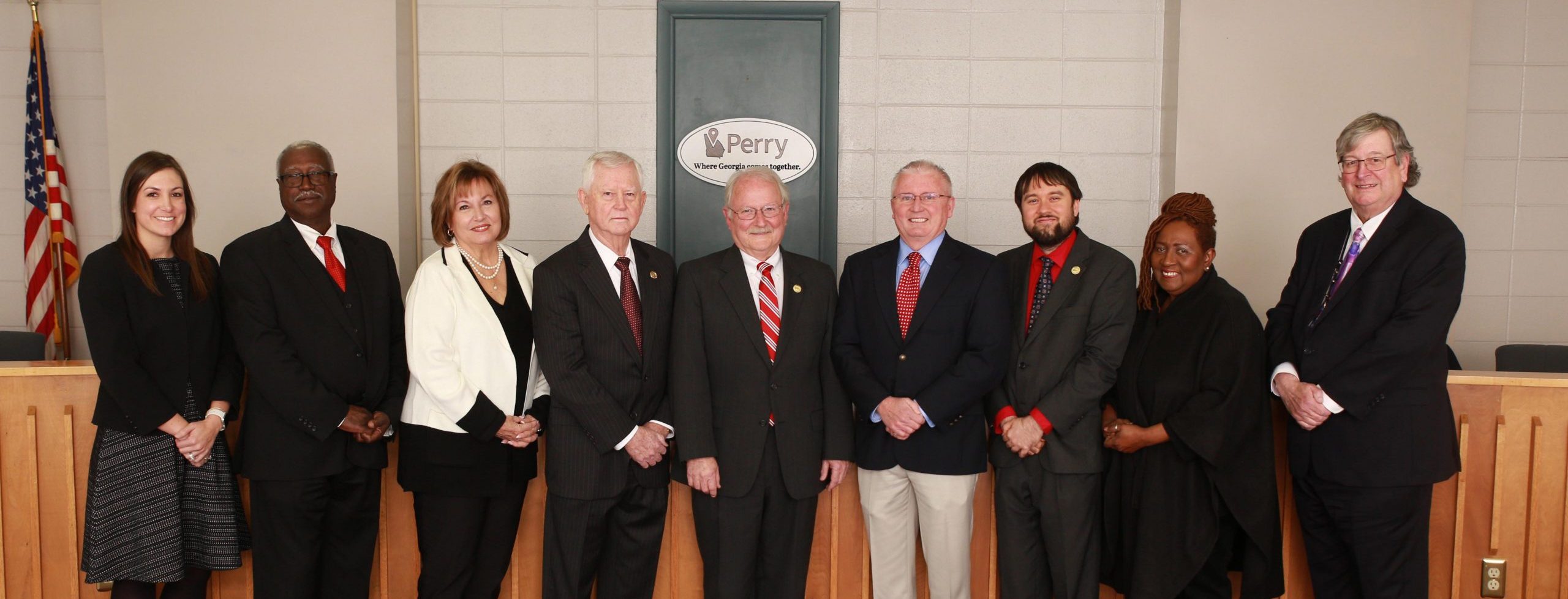 City Council Members stand in a line smiling at the camera